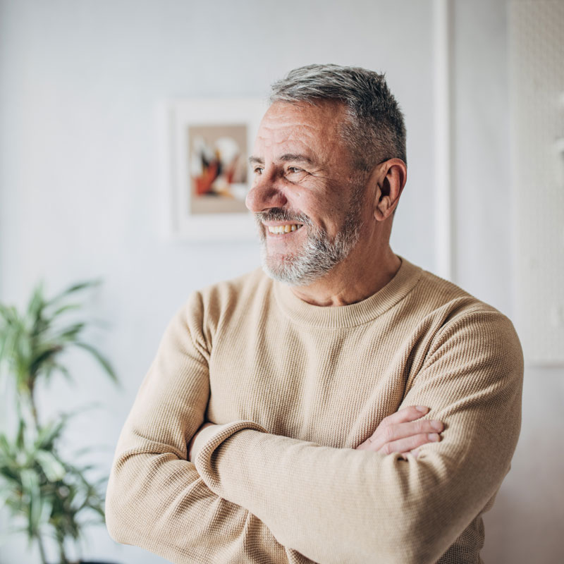 senior man with arms crossed smiling