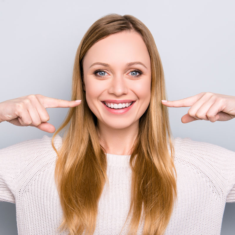 woman pointing at teeth